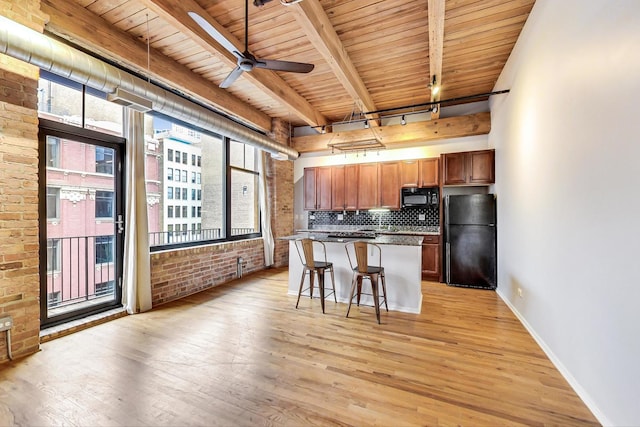 kitchen featuring black appliances, plenty of natural light, light wood finished floors, and track lighting