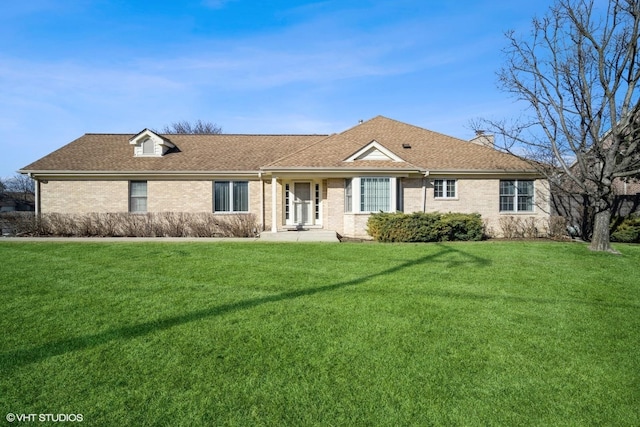 single story home with a front lawn, a shingled roof, and brick siding