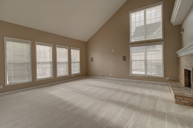 unfurnished living room with a brick fireplace, carpet, baseboards, and a wealth of natural light