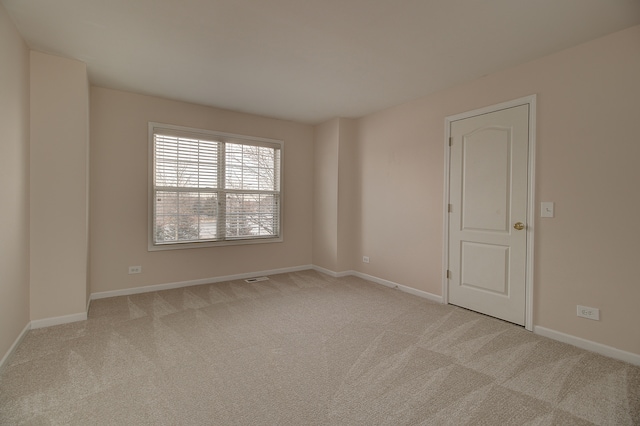 unfurnished room with baseboards and light carpet