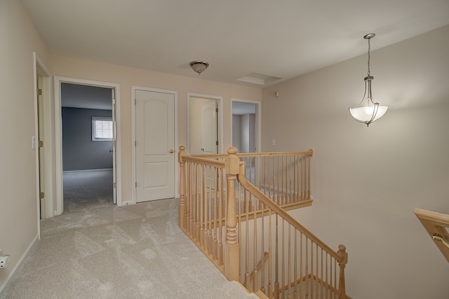 corridor with baseboards, an upstairs landing, and light carpet