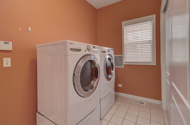 laundry area featuring light tile patterned floors, baseboards, visible vents, laundry area, and washing machine and dryer