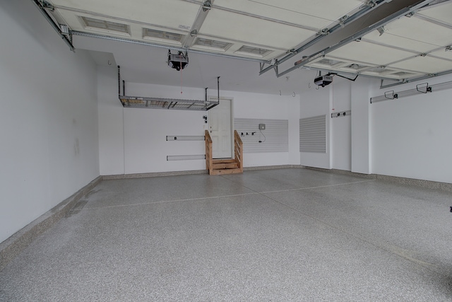 garage with baseboards and a garage door opener