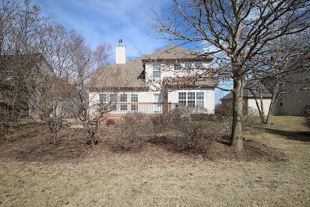 rear view of property featuring a deck and a chimney