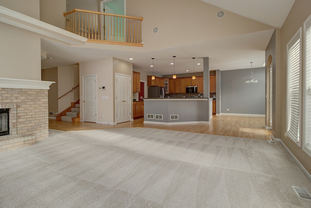 unfurnished living room featuring baseboards, a fireplace, visible vents, and light carpet