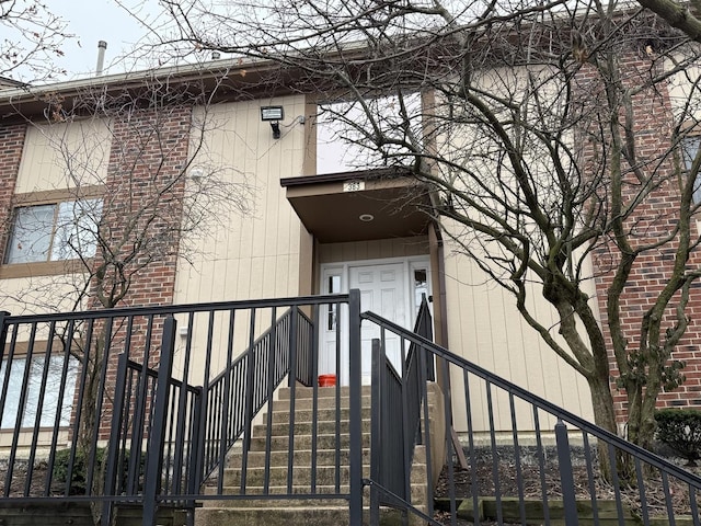 doorway to property featuring brick siding