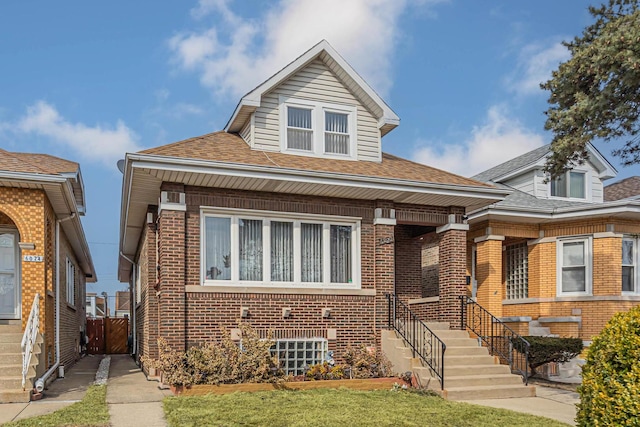 view of front of house featuring brick siding and roof with shingles