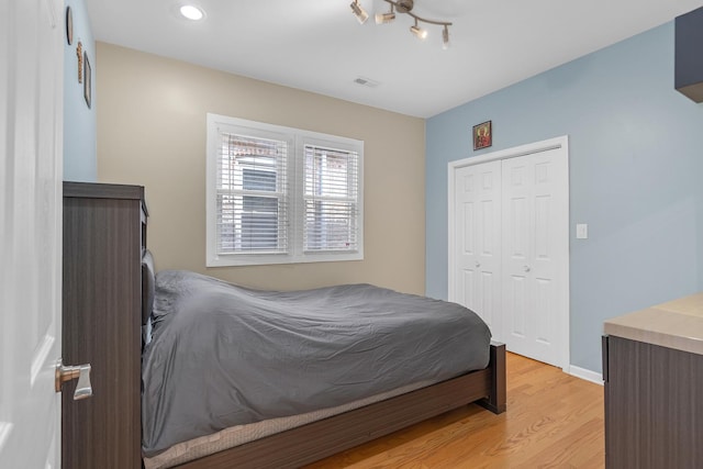 bedroom featuring recessed lighting, visible vents, baseboards, light wood-style floors, and a closet