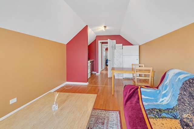 living area with lofted ceiling, wood finished floors, and baseboards