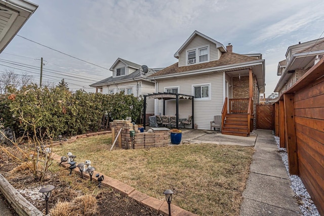 back of house featuring a patio, a shingled roof, a lawn, fence, and a pergola