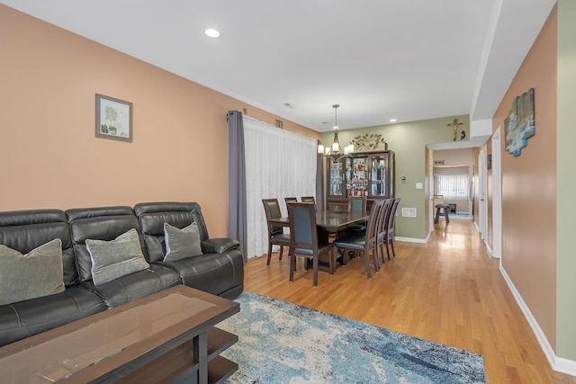 living area with recessed lighting, an inviting chandelier, light wood-style flooring, and baseboards