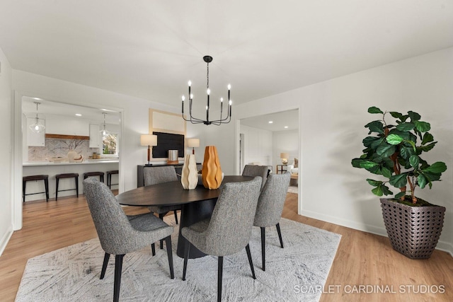 dining area featuring baseboards, wood finished floors, and a chandelier