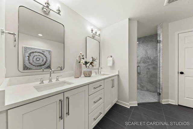 full bathroom featuring tile patterned floors, a sink, double vanity, and a shower stall