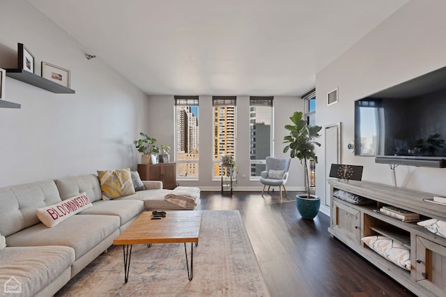 living area featuring dark wood-style flooring, visible vents, and baseboards