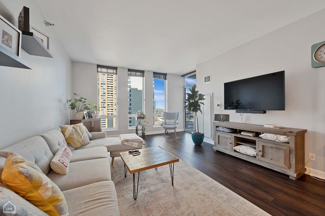 living area featuring baseboards, visible vents, and wood finished floors