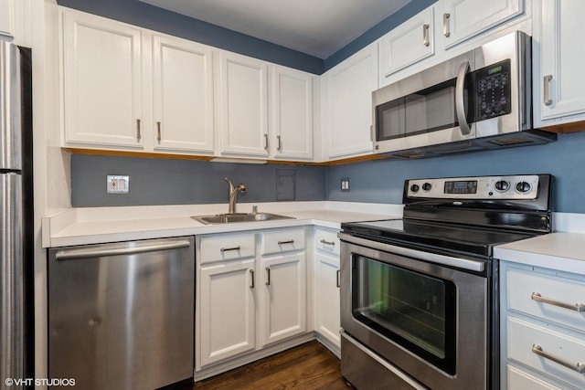 kitchen with white cabinetry, stainless steel appliances, a sink, and light countertops