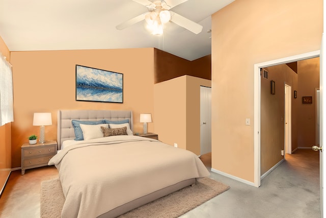 bedroom with a closet, light colored carpet, vaulted ceiling, ceiling fan, and baseboards