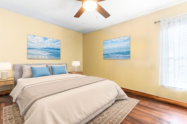 bedroom featuring ceiling fan, baseboards, and wood finished floors