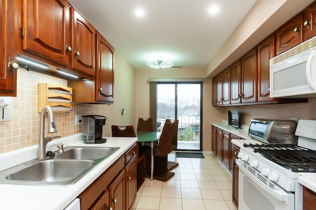 kitchen featuring white appliances, light countertops, a sink, and light tile patterned floors