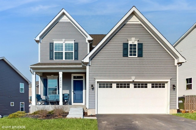 traditional home featuring driveway, covered porch, and an attached garage