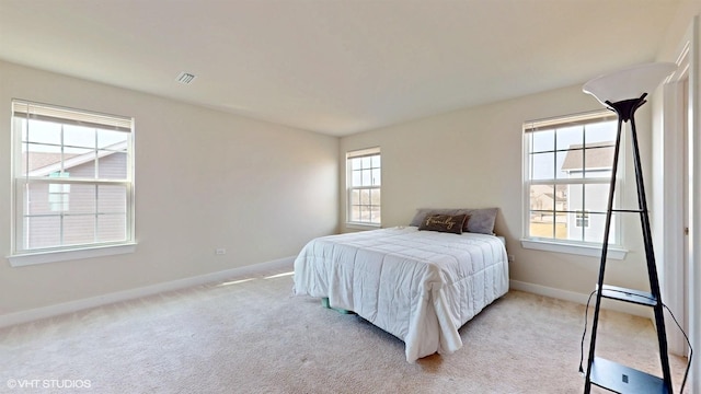 bedroom featuring visible vents, baseboards, and light colored carpet