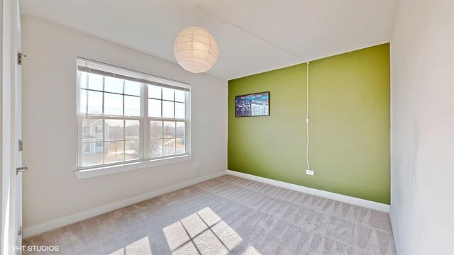 carpeted spare room featuring baseboards