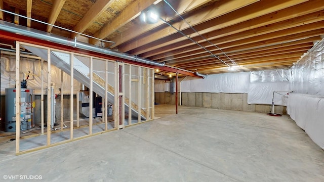 unfinished below grade area featuring heating unit and gas water heater