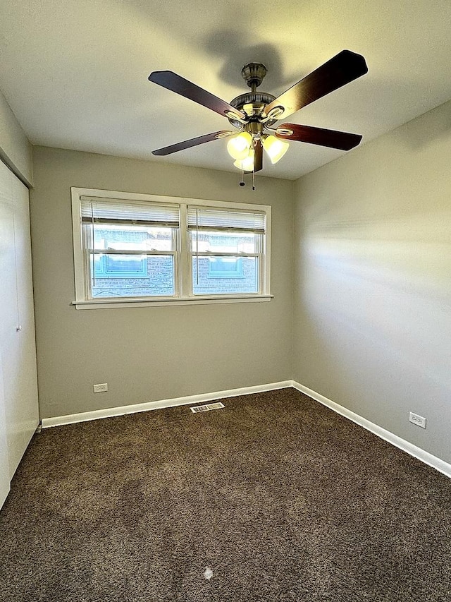 empty room with a ceiling fan, carpet, visible vents, and baseboards