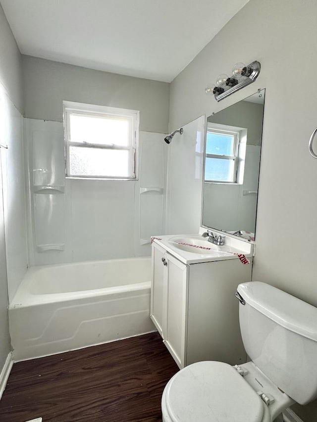 full bath with  shower combination, vanity, wood finished floors, and toilet