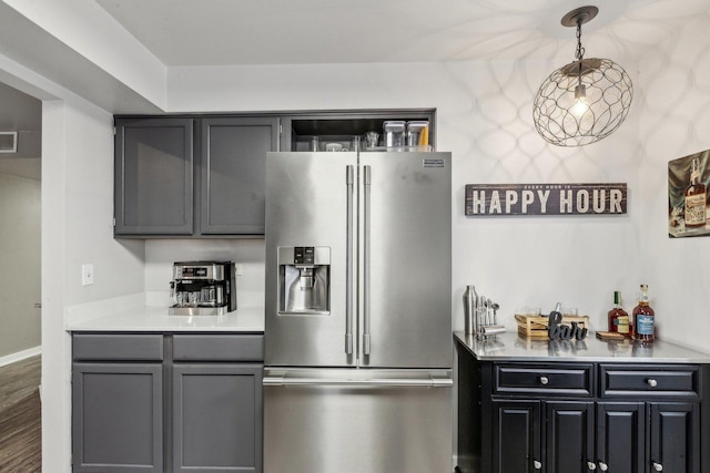 kitchen featuring light countertops, visible vents, gray cabinetry, high quality fridge, and wood finished floors