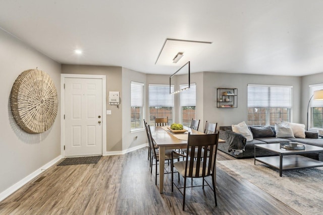 dining space with baseboards and wood finished floors