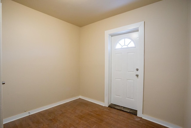 foyer entrance featuring baseboards and dark wood finished floors