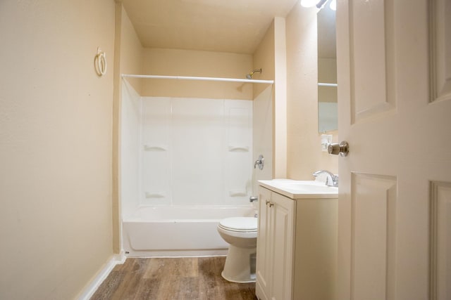 bathroom with baseboards, toilet, shower / tub combination, wood finished floors, and vanity