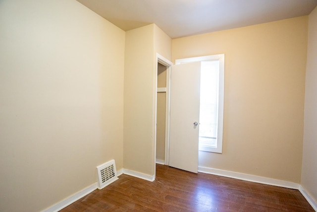 interior space featuring baseboards, visible vents, and dark wood-style flooring