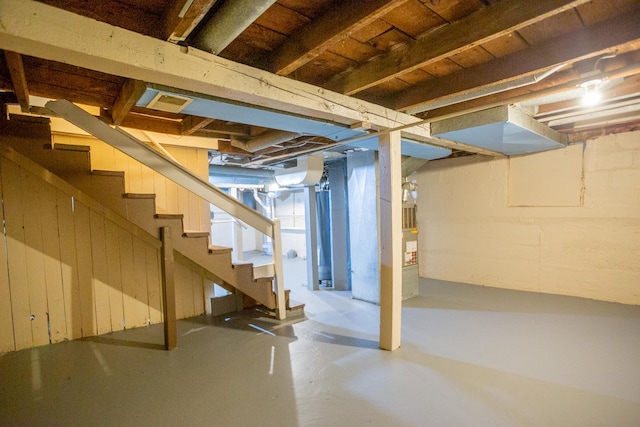 unfinished basement featuring heating unit and stairs