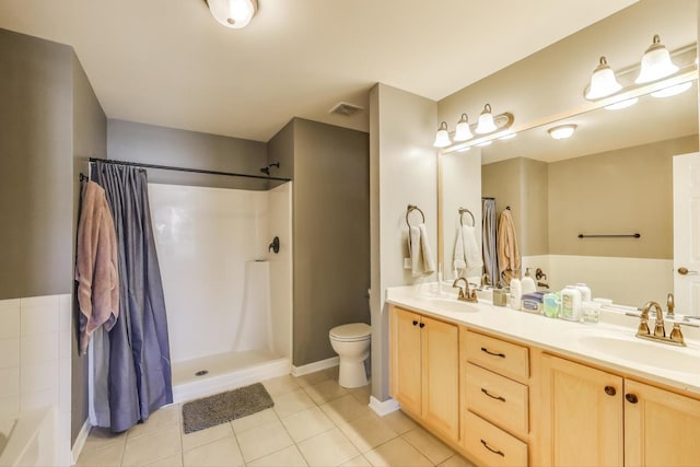 bathroom with toilet, tile patterned flooring, double vanity, and a sink