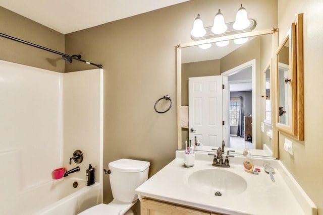 bathroom featuring toilet, vanity, and washtub / shower combination