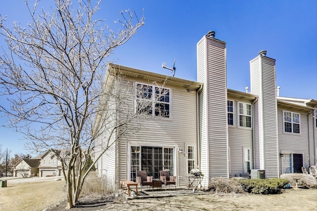 rear view of house with a chimney and a patio area