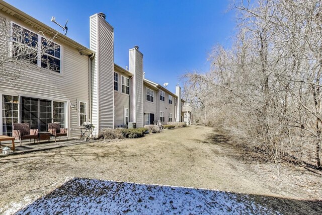 back of house featuring a patio area and a chimney