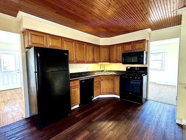 kitchen featuring black appliances, a sink, dark wood finished floors, and crown molding