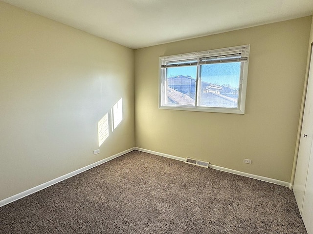 unfurnished room featuring carpet, visible vents, and baseboards