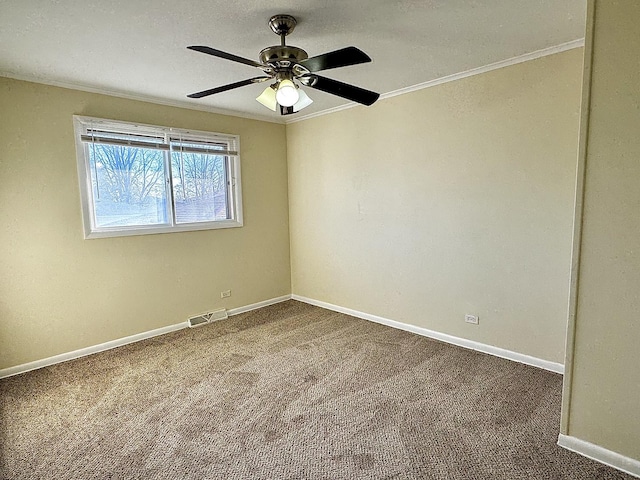 spare room featuring visible vents, ornamental molding, carpet flooring, ceiling fan, and baseboards