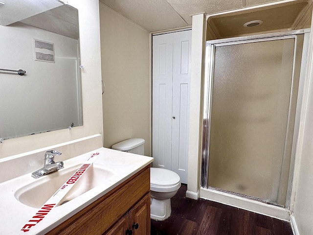 full bath featuring vanity, a shower stall, toilet, and wood finished floors