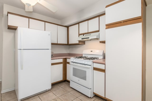 kitchen featuring light tile patterned flooring, under cabinet range hood, white appliances, white cabinetry, and light countertops