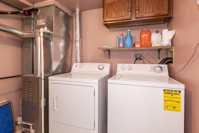 clothes washing area featuring cabinet space and washer and dryer