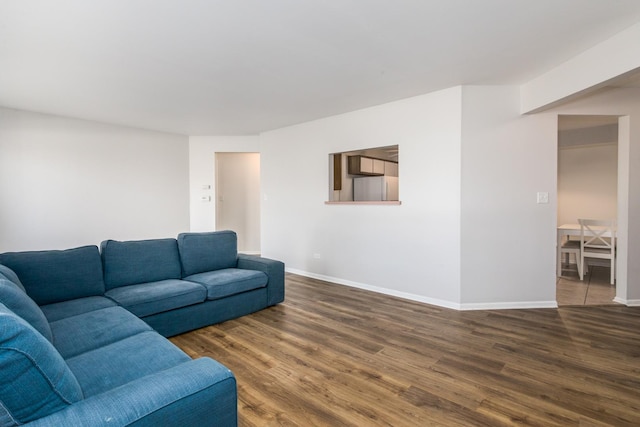 living area with baseboards and wood finished floors