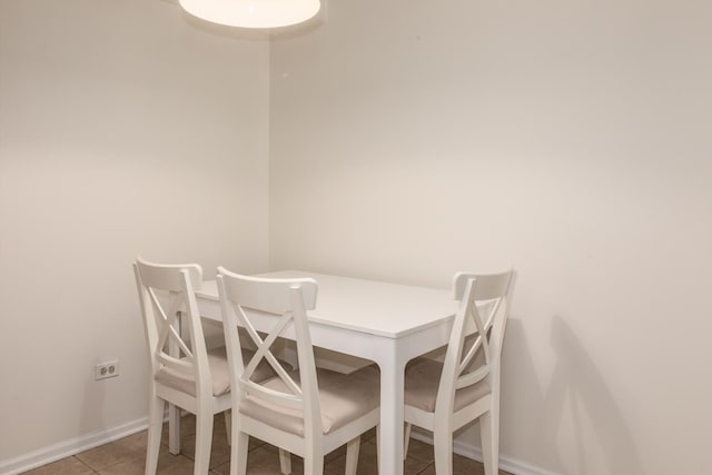 dining space with light tile patterned floors and baseboards