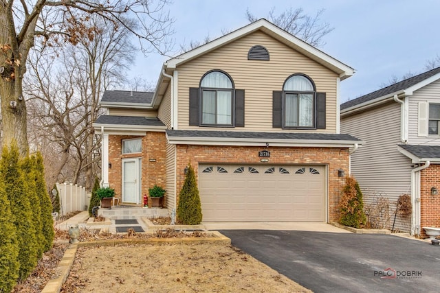 view of front of home with aphalt driveway, brick siding, roof with shingles, an attached garage, and fence