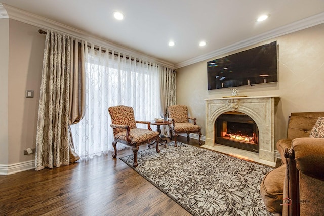 living area featuring recessed lighting, wood finished floors, a high end fireplace, and crown molding