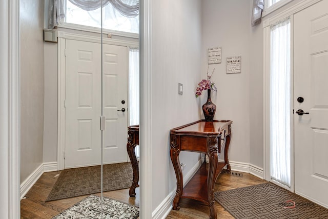 entryway featuring baseboards and wood finished floors